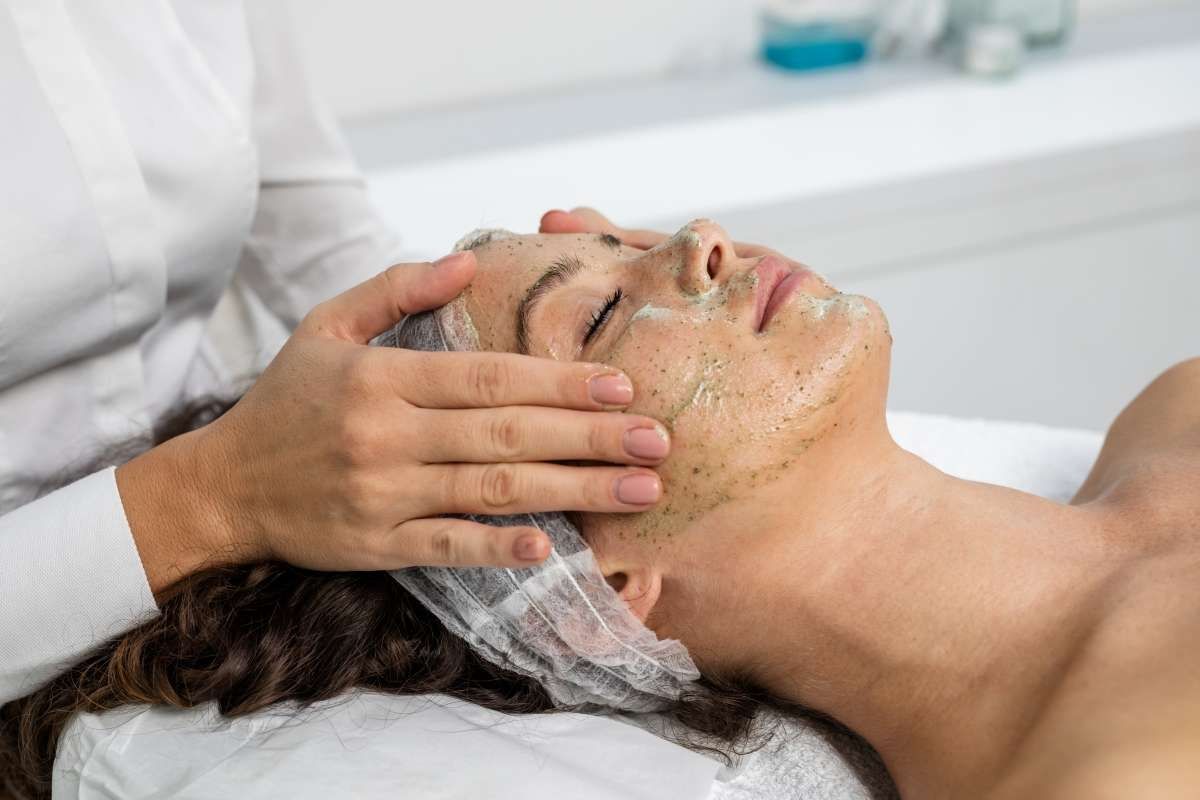 Junge Frau wird mit einer grünen Maske behandelt